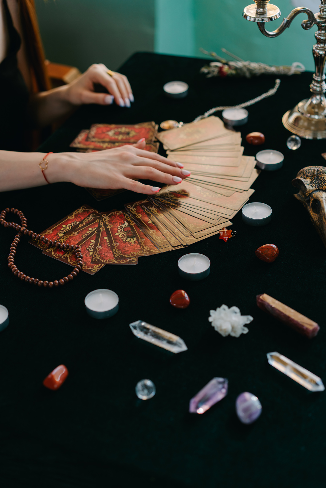 Crop woman fortune telling by divination cards and crystals